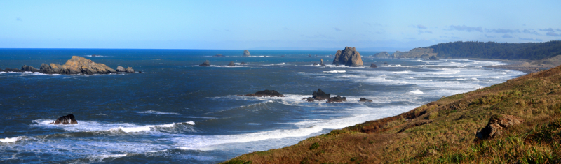 [Several photos stitched together expanding upon the prior image showing edges of land as well as the many white-capped waves.]